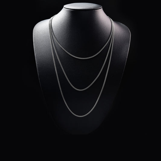 Layered silver chain necklace on black display bust