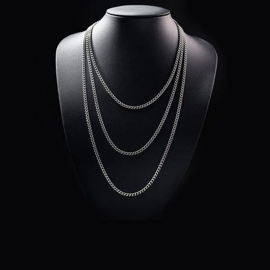 Layered silver chain necklace on black display bust